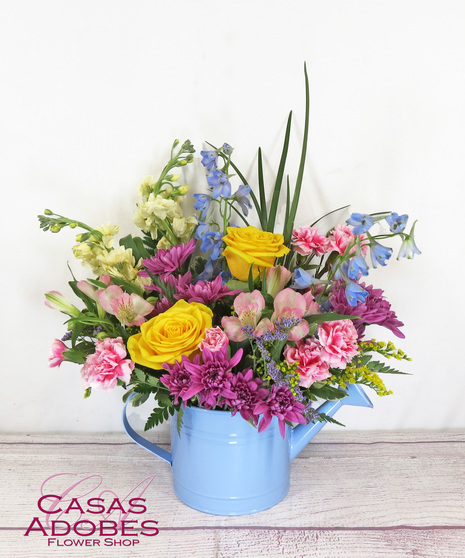 Yellow roses, pink alstroemeria, lavender cushion chrysanthemums, peach stock look oh-so-lovely with pink miniature carnations presented in a fun watering can