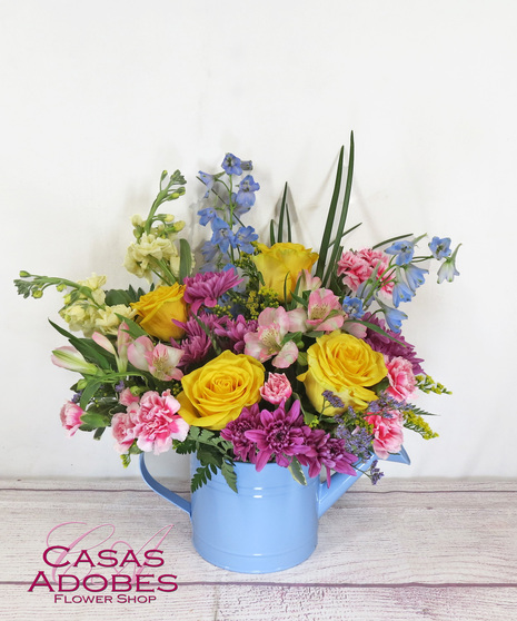 Yellow roses, pink alstroemeria, lavender cushion chrysanthemums, peach stock look oh-so-lovely with pink miniature carnations presented in a fun watering can