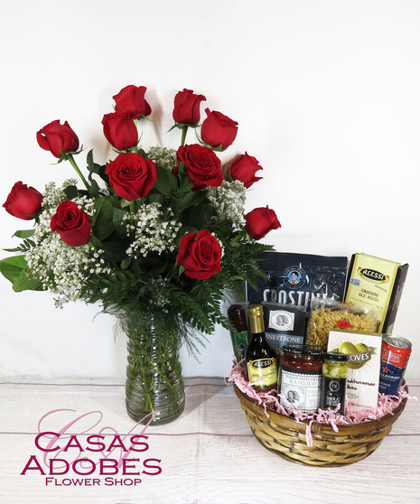 Basket filled with pasta, sauce, breadsticks, olives, sparkling water