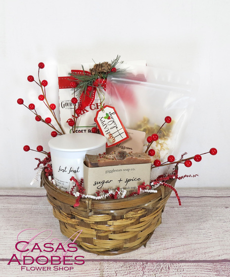 Basket filled with holiday flavors with  holiday coffee ,  gingerbread men cookies, chocolate cookies, cocoa, bath salts, and candles